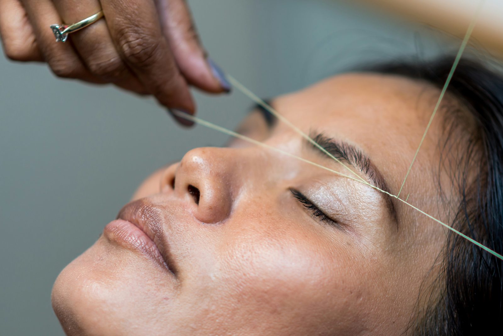 Wenkbrauwbehandeling met threading van dichtbij in een schoonheidssalon