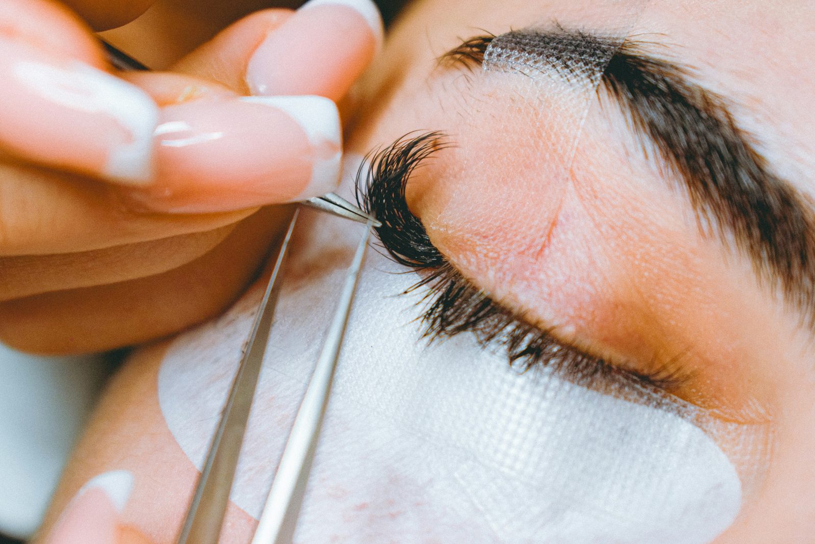 Wimperstylist isoleert een wimper tijdens een lashbehandeling