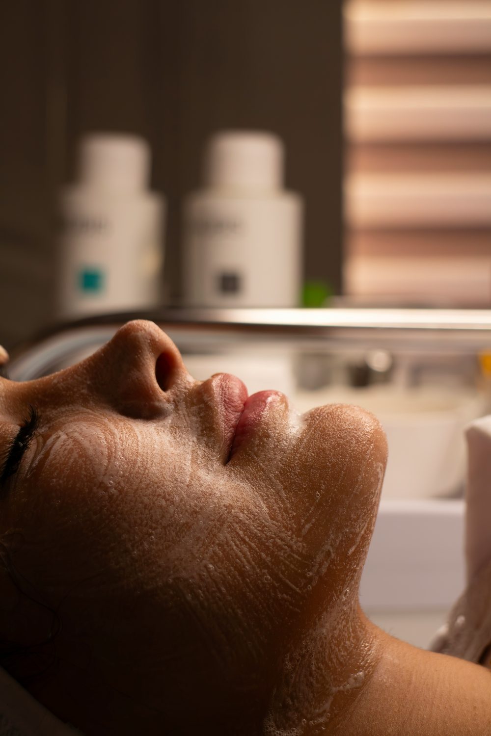 Close-up van een ontspannen gezichtsbehandeling in de salon met een dun laagje product op de huid